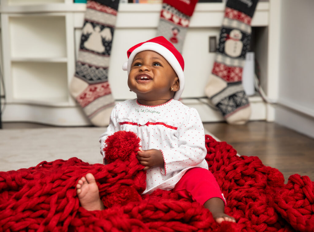 toddler decorating Christmas tree and christmas PJs